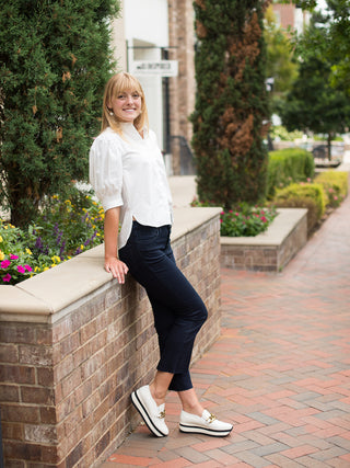 a dramatic button up blouse with statement sleeves in ivory perfect for day to night looks shown with black pants