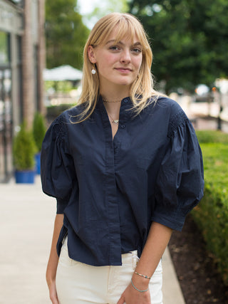 a dramatic button up blouse with statement sleeves in navy perfect for day to night looks