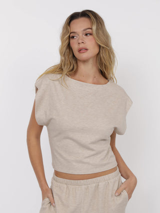 beige knit top with bold shoulders and round neckline