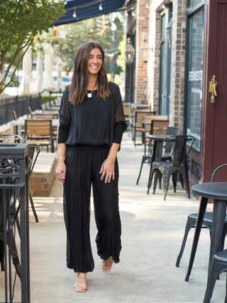a black italian silk blouse with semi sheer three quarter sleeves made for luxury everyday dressing shown with matching pants