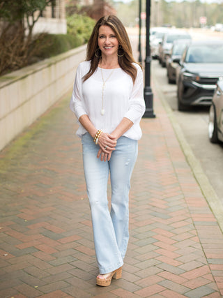 white three quarter sleeve sheer silk top over solid tank with banded waist worn with light blue jeans