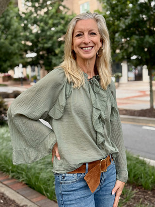 green blouse with ruffled long sleeves and center ruffle with tie
