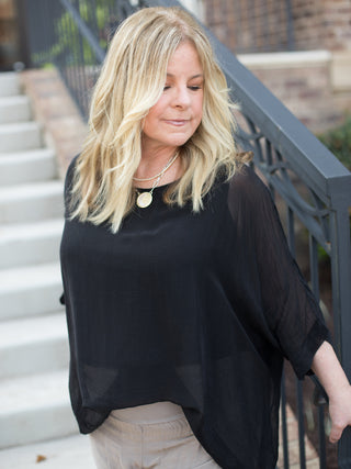 a black italian silk blouse with semi sheer sleeves and a flowing fit great for summer to fall fashion