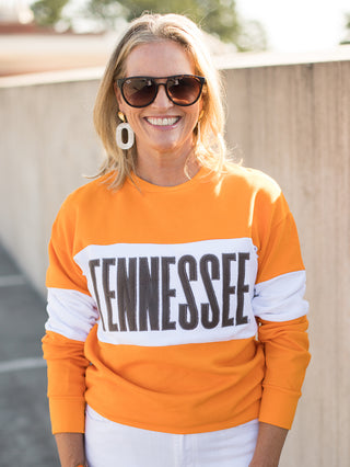 a tennessee sweatshirt with orange and white color block perfect for fall football games and vols pride