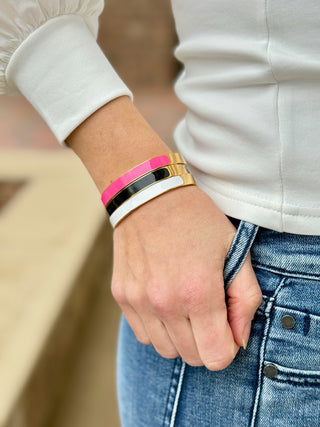 a stack of pink black and white colored bangles