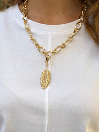 a simple chunky gold oval linked necklace with a leaf pendant