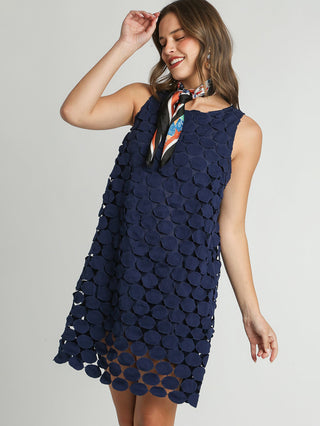 a sleeveless shift dress in navy color and lace circle pattern
