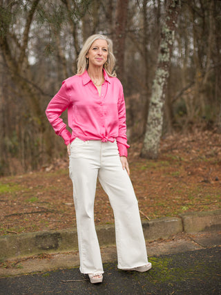 a pair of off white mid rise wide leg denim pants shown with pink silk button down blouse