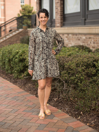 elegant black and white print button front long sleeve midi dress worn with tan sandals