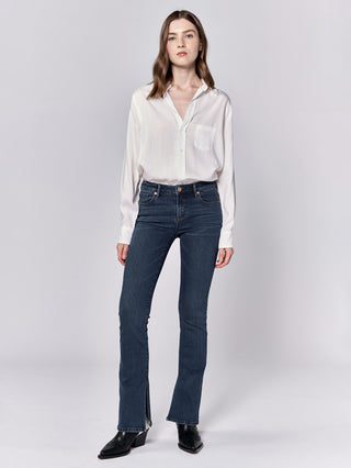 slim fit dark wash blue denim jeans with ankle splits worn with a white blouse
