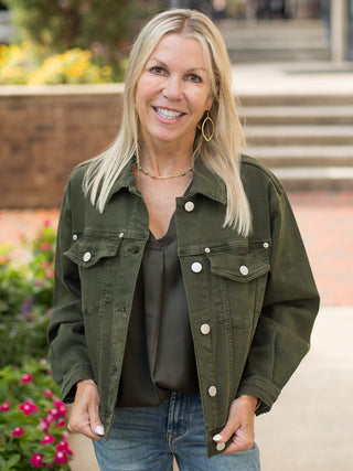 an olive green shacket with silver buttons and a relaxed silhouette perfect for fall fashion layering