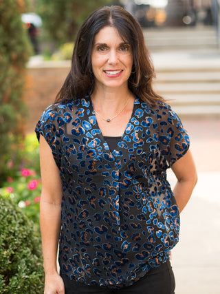 a sheer navy velvet blouse with orange leopard print and short sleeves perfect for seasonless luxury