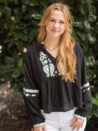 a boho chic blouse with white embroidery on the black long sleeve top perfect for summer to fall fashion