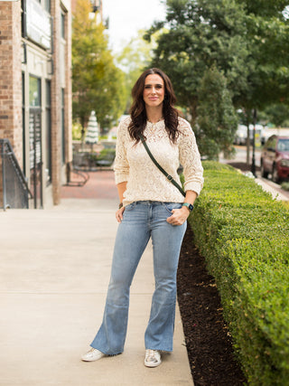 a long sleeve lace like crochet top in off white perfect for layering and feminine fall fashion shown with denim pants