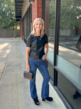 a black vegan leather short sleeve shirt in rocker chic style perfect for fall and winter fashion shown with denim