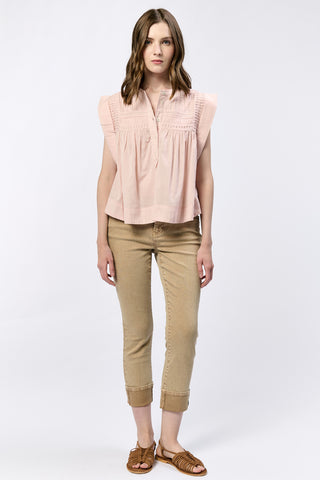 blush shirt with textured half button front paired with tan pants 