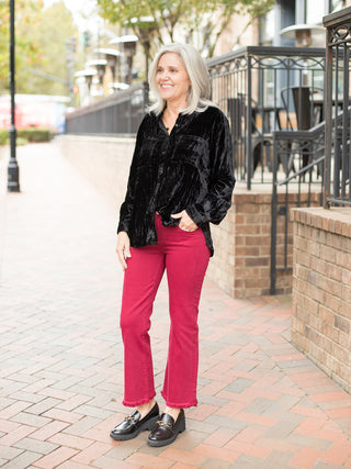 wear this black velvet button down blouse to as a christmas eve outfit paired with red flared pants and black loafers