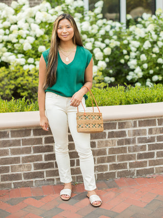 a lightweight green t shirt with a v neckline and sleeveless silhouette shown with white pants