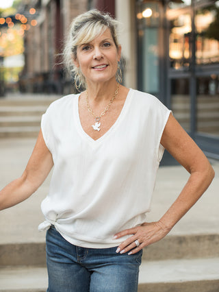 a lightweight white t shirt with a v neckline and sleeveless silhouette