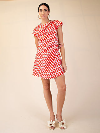 a soft and flattering mini dress with a vibrant red and white diamond pattern worn with white heels