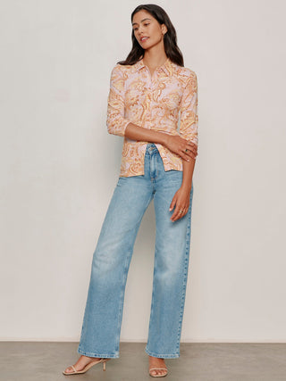 a whimsical collared button front top with a light pink and taupe abstract pattern paired with blue jeans