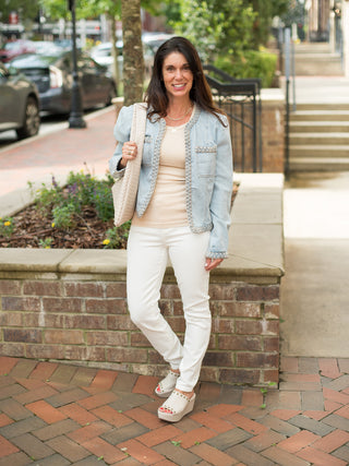 a light wash denim jacket with braided trim perfect to layer for summer to fall fashion shown with white platform shoes