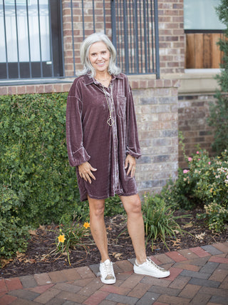 a dark purple shirt dress in velvet with buttons down the front and long statement sleeves shown with sneakers