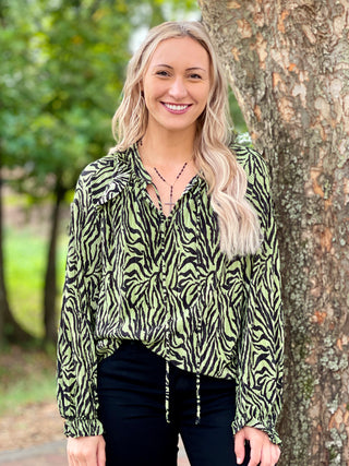 a loose fitting animal print top in green and black with feminine long sleeves and pleated fabric great for statement wear