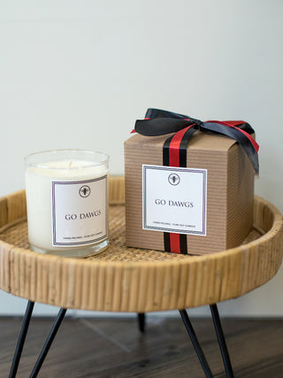 a hand poured amber musk and sage candle and gift box with go dawgs printed on both