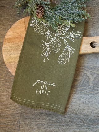 decorate with this green and white tea towel that reads peace on earth as christmas decor or give as a holiday gift