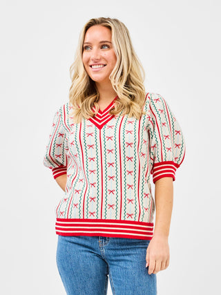 a cute white holiday sweater top with red and green stripes and bow ties