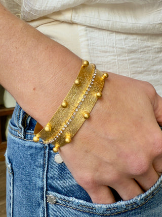 a glowing gold studded cuff bracelet