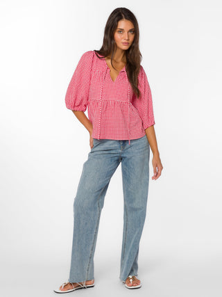 a cherry red picnic top with an a line and split neck with front tie worn with blue jeans