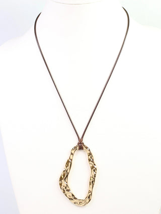 a brown corded necklace with a hammered gold oval pendant