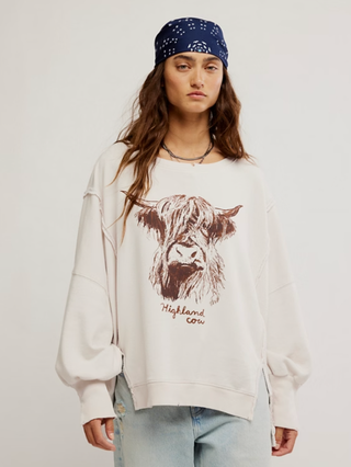 white sweatshirt with a brown highland cow design