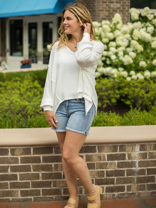 an oversize ivory waffle knit top with long sleeves and a v neck perfect for your loungewear collection shown with denim shorts