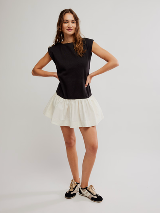 a sleek and sporty black and white mini dress with pockets paired with black sneakers