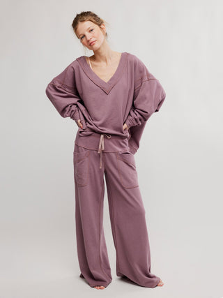 a super relaxed off the shoulder free people elderberry colored sweater worn with matching pants