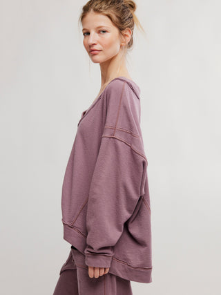 a super relaxed off the shoulder free people elderberry colored sweater worn with matching pants