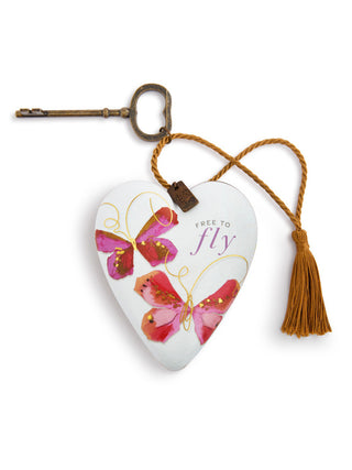 a white heart adorned with painted butterflies and a vintage key with rope for hanging