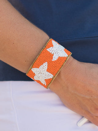 an orange and white cuff bracelet with star designs perfect for clemson tennessee and auburn football fans and game day style