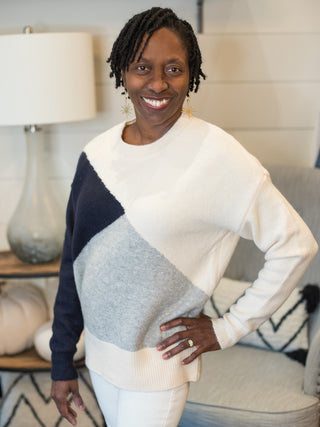 a colorblock sweater in navy white and gray in a flattering fit perfect for fall and winter fashion