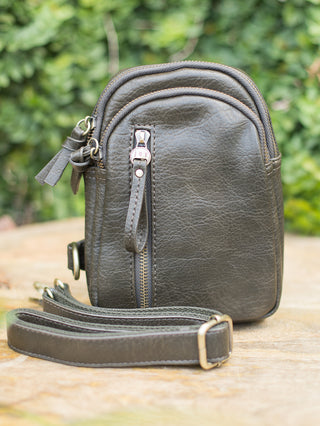 an olive purse in faux leather with versatile sling straps and zipper compartments great for on the go 