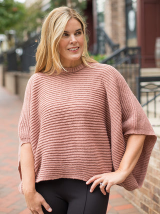 a textured top in pink peach with statement long sleeves and a ribbed high neckline great for dramatic styling
