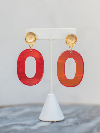 a pair of gold and red oval statement earrings in lightweight acrylic 