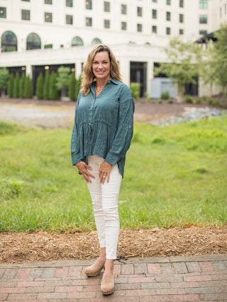 a long sleeve button down blouse in teal with a tie at the waist and relaxed fit for fall fashion shown with ivory pants