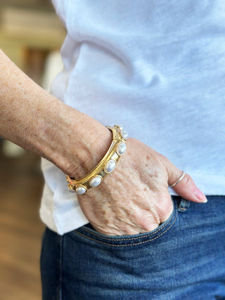 a cute gold bracelet with bright pearl accents