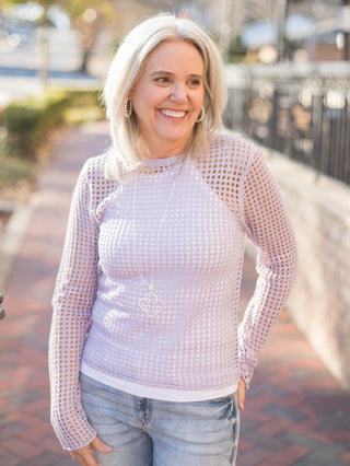 a lavender open knit crochet top with long sleeves 