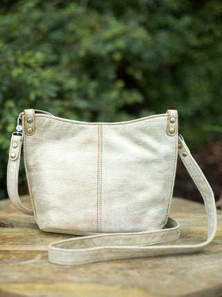 a metallic gold purse with crossbody straps perfect for everyday accessorizing and a touch of glamor