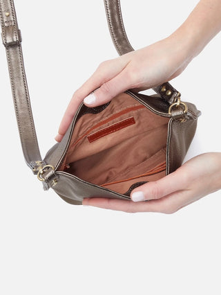 a metallic bronze leather crossbody purse with a magnetic closure and gold accents featuring interior pockets